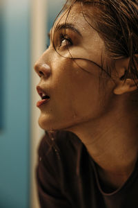 Female athlete with sweat on face looking away in locker room