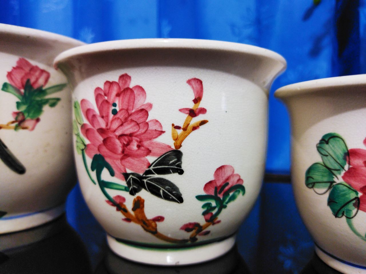 CLOSE-UP OF VASE ON TABLE AGAINST WALL