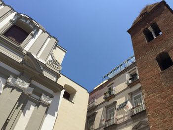 Low angle view of buildings against clear blue sky