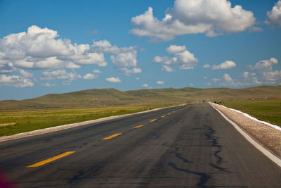 Empty road along countryside landscape