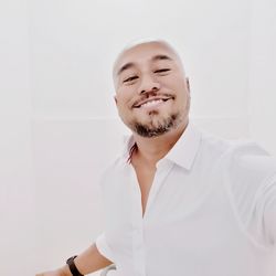 Portrait of young man against white wall