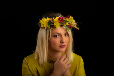 Close-up portrait of beautiful woman against black background