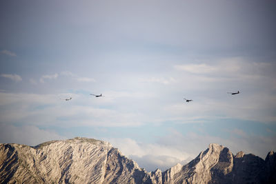 Airplanes flying above a mountain and pulling two other