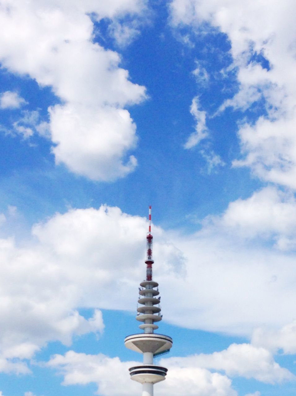 sky, low angle view, cloud - sky, built structure, architecture, cloudy, building exterior, tower, cloud, communication, communications tower, blue, tall - high, spire, famous place, travel destinations, day, outdoors, international landmark, tourism