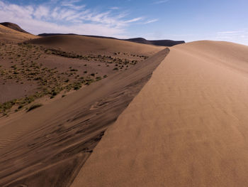 Sand dune in desert against sky