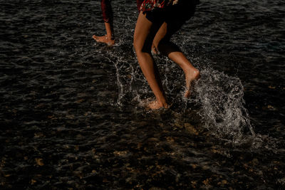 Low section of person running in sea