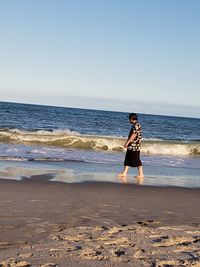 Boy on beach against sky