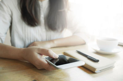 Midsection of woman using laptop on table