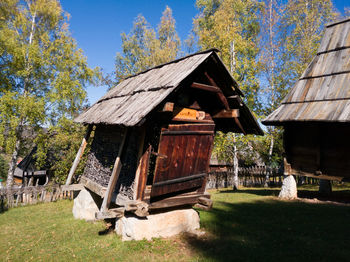 Built structure on field by house against sky