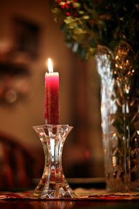 Close-up of lit candle on table