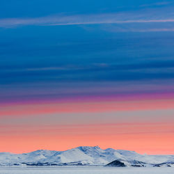 Scenic view of snowcapped mountains against dramatic sky