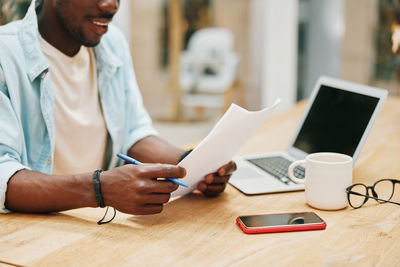 Midsection of man working at table