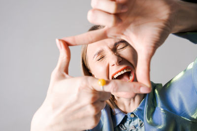 Cropped hand of woman gesturing against white background
