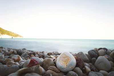 Stones on beach against clear sky