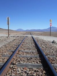 Railroad track against clear blue sky