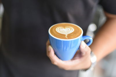 Close-up of man holding coffee cup