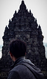 Rear view of woman at temple against building