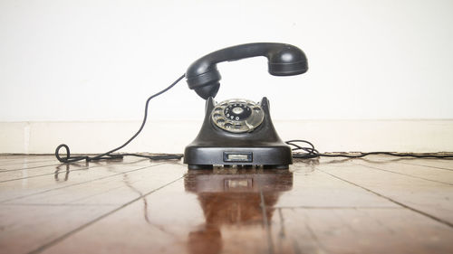 Telephone booth on table against wall