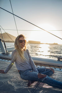 Young woman in sunglasses against sea