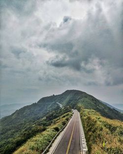 Road leading towards mountains against sky