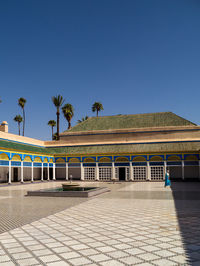 Building by swimming pool against clear blue sky