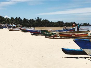 Boats moored on beach against sky