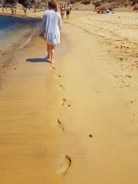 Low section of woman walking on beach