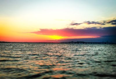 Surface level of lake against sky during sunset