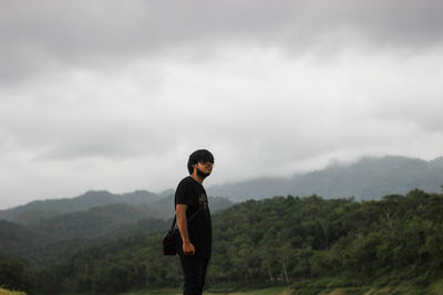 Full length of man standing on mountain against sky