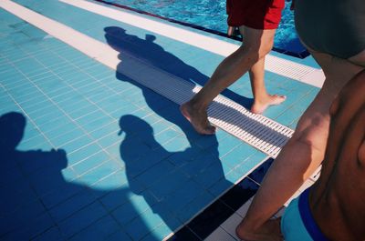 Low section of people standing by swimming pool