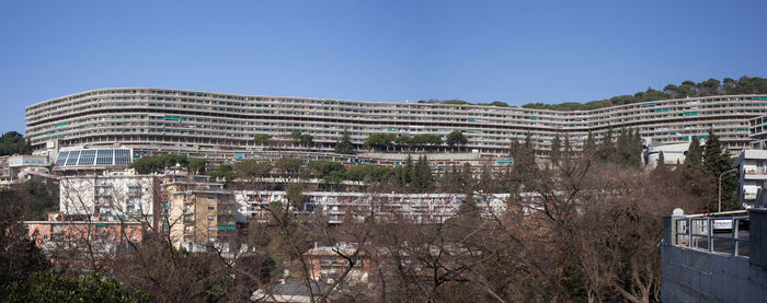 Buildings in city against clear blue sky