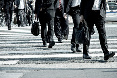 Low section of business people walking on road