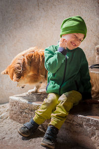 Boy with dog sitting outdoors