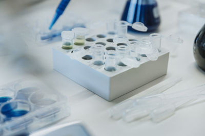 Woman filling liquid in test tube plate at laboratory