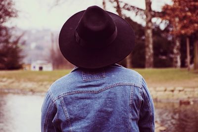 Rear view of man wearing hat against trees