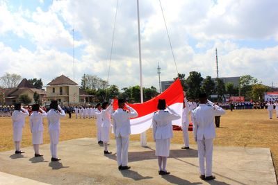 Group of people in traditional clothing against sky