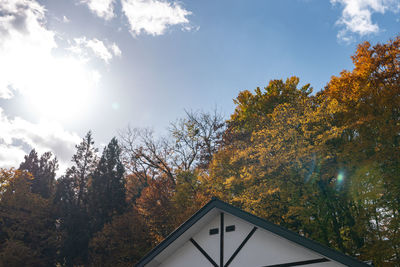 Low angle view of trees and building against sky