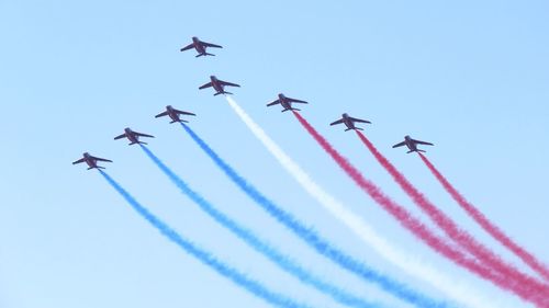 Low angle view of airshow against clear sky