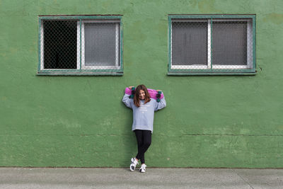 Full length of woman standing against building