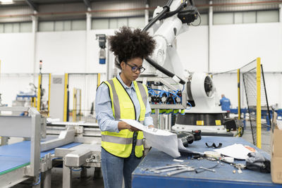 Engineer examining blueprint in factory