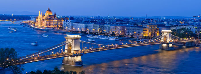 Panoramic view of illuminated chain bridge over danube river at night