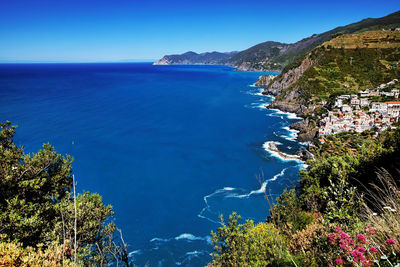 High angle view of sea by cinque terre against clear blue sky