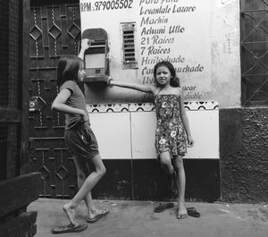 Portrait of young woman standing against wall