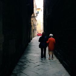 Rear view of man walking in alley