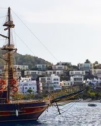 Boats moored in city against clear sky