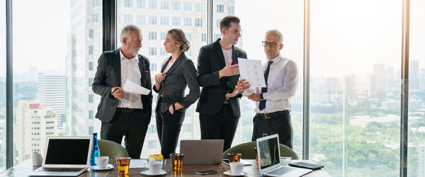 People working on table by window