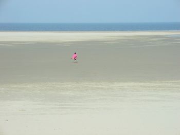 Rear view of woman walking at beach