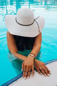 Midsection of woman sitting in swimming pool