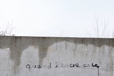 Text on wall against clear sky