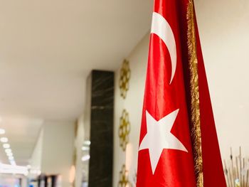 Close-up of flags hanging against white wall